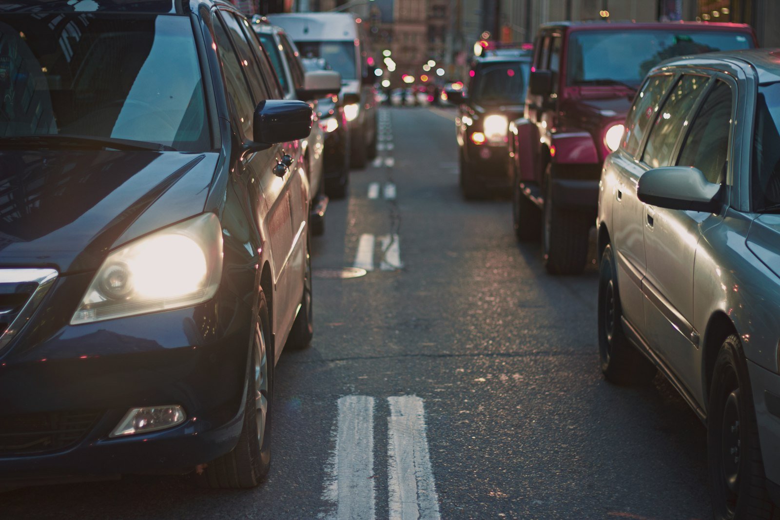 Filas de automóviles con los faros encendidos en una vialidad durante el traslado al trabajo