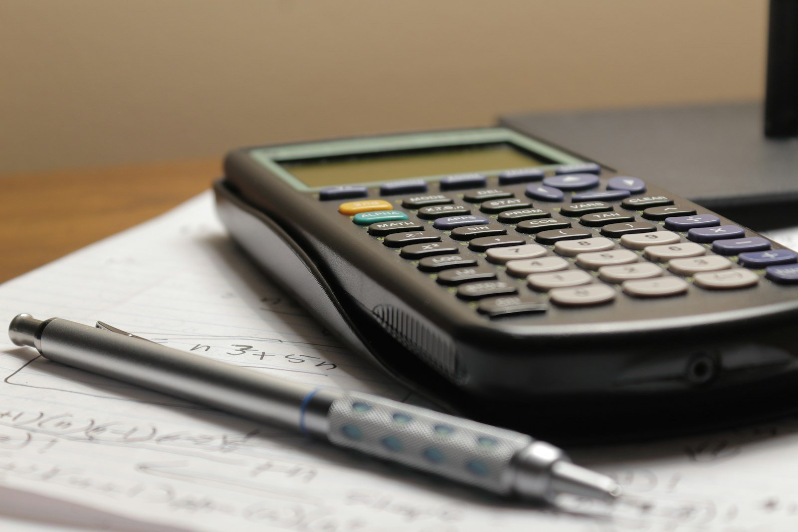 Calculadora y pluma sobre hojas de cálculo