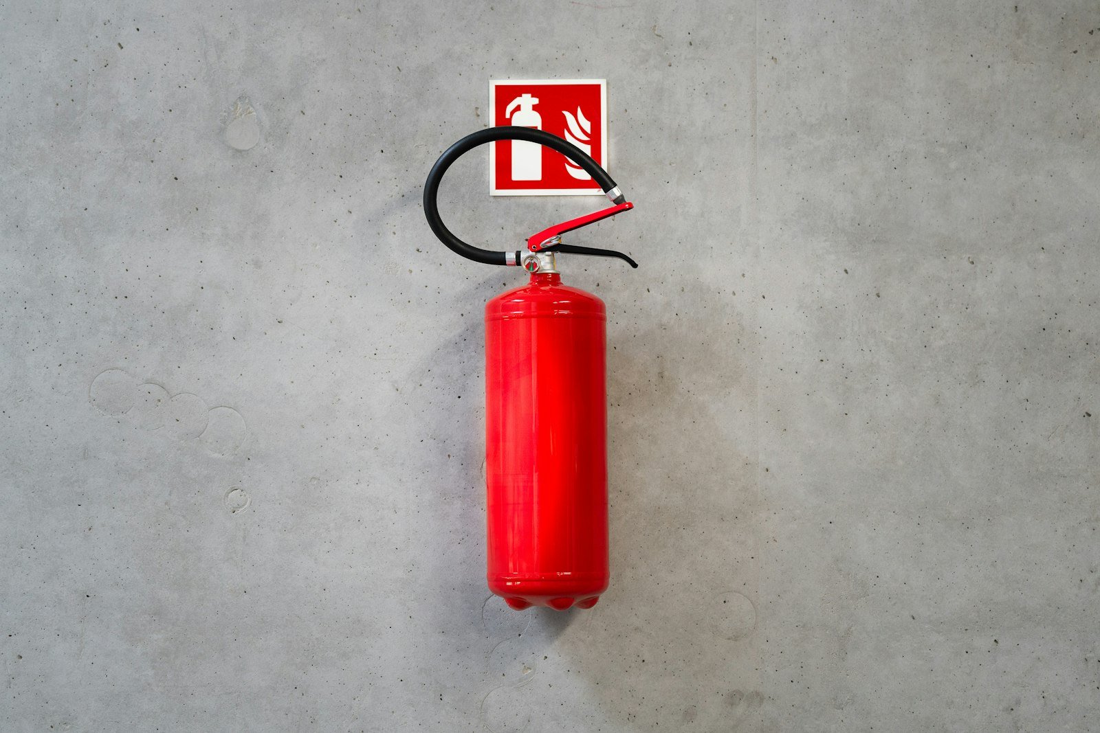 Extintor rojo colgado en la pared de un inmueble