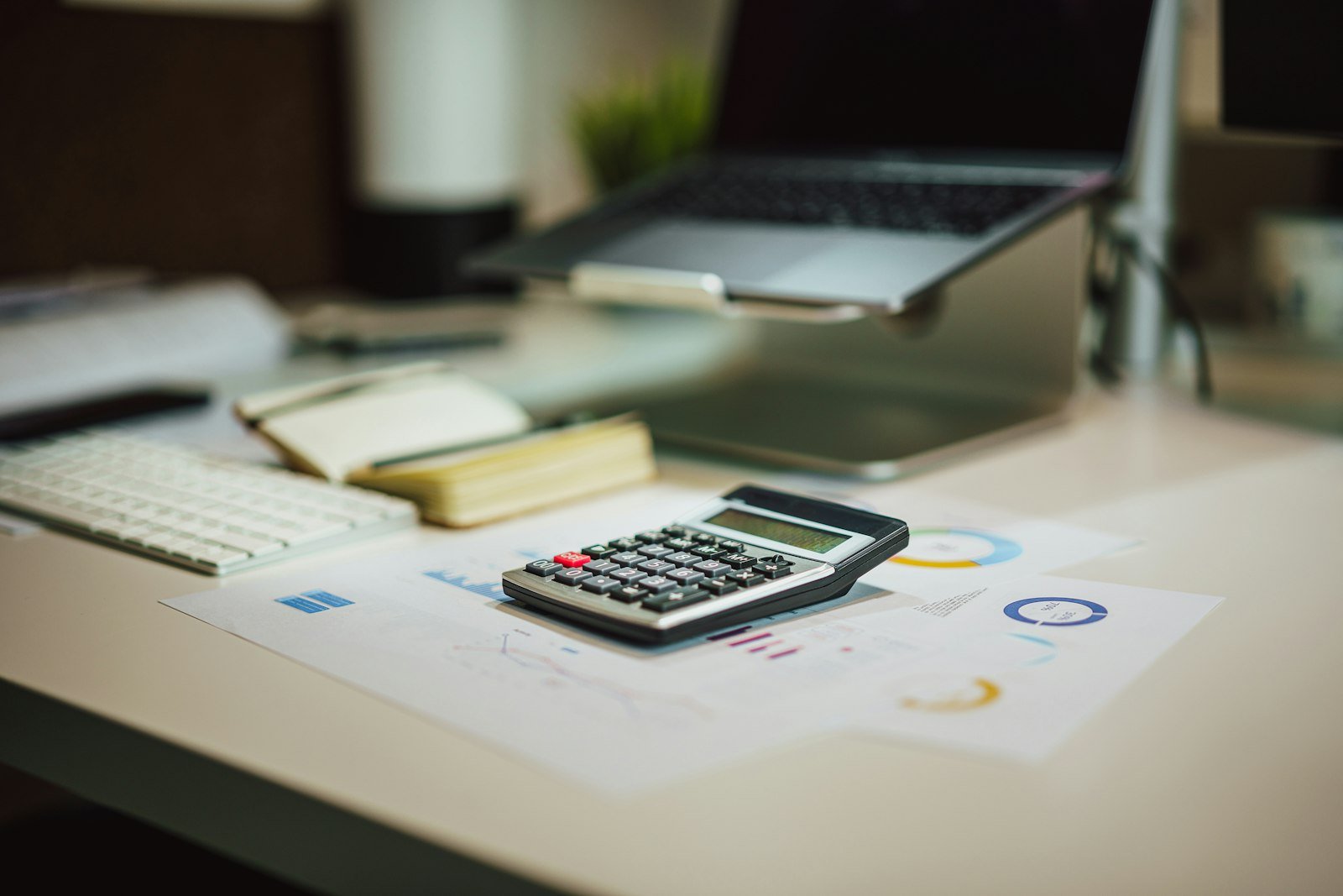 Calculadora sobre un escritorio junto a una laptop para el cálculo de una liquidación