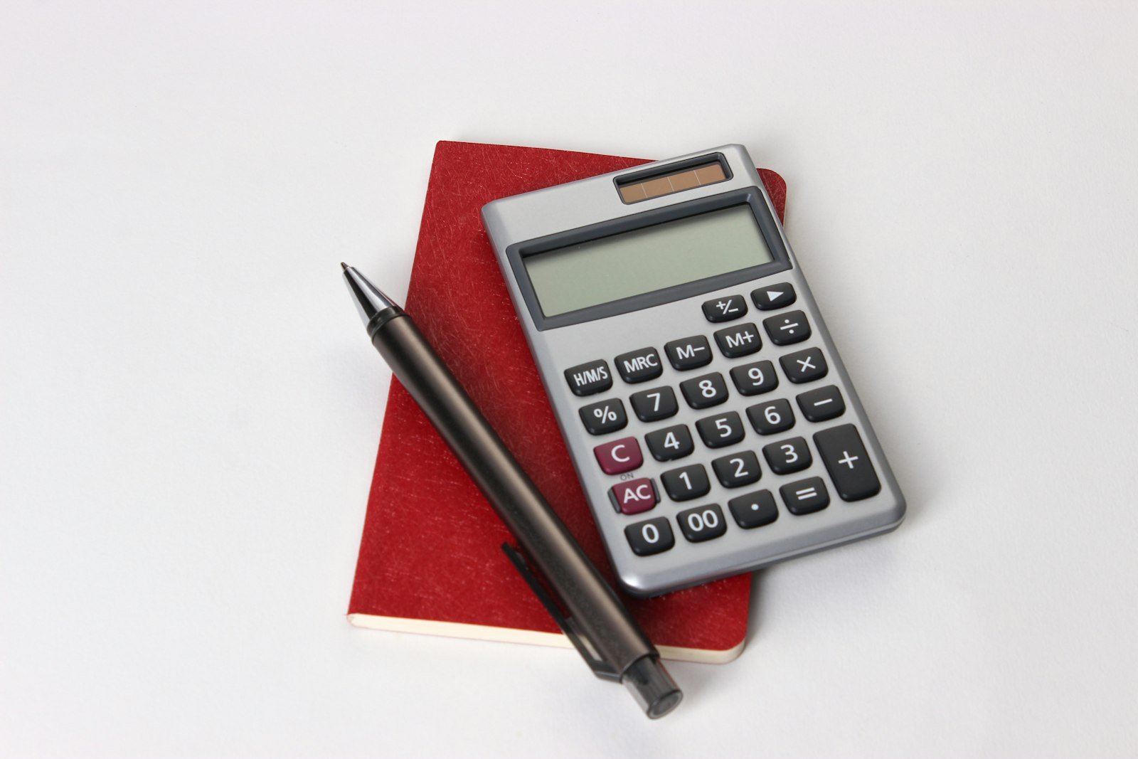 Calculadora y pluma sobre un escritorio, cálculo de salarios caídos e intereses